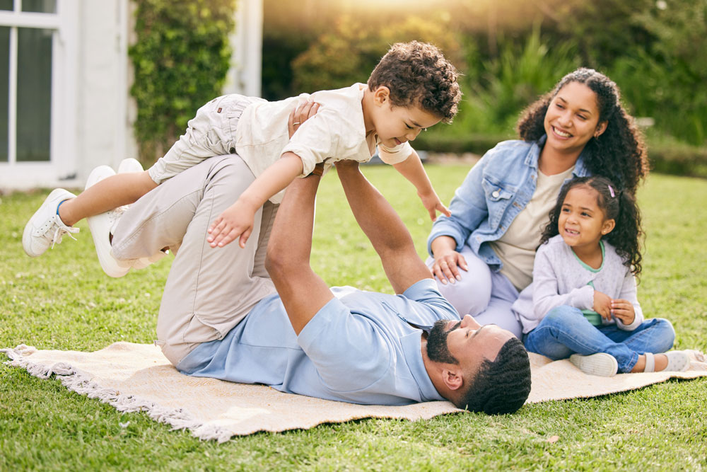 Parent playing with children in a sunny field